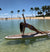 Yumi doing a yoga pose on her surfboard