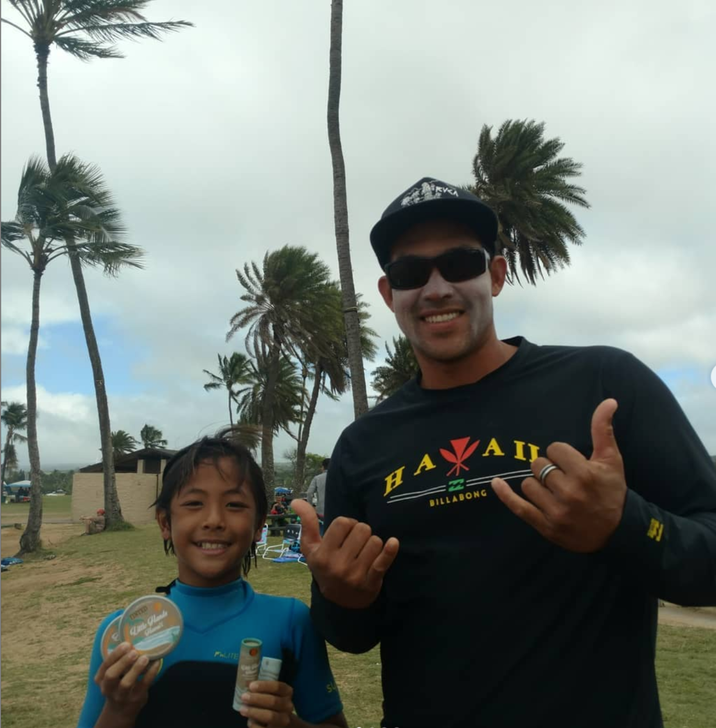 Father and son holding up Little Hands Hawaii Products