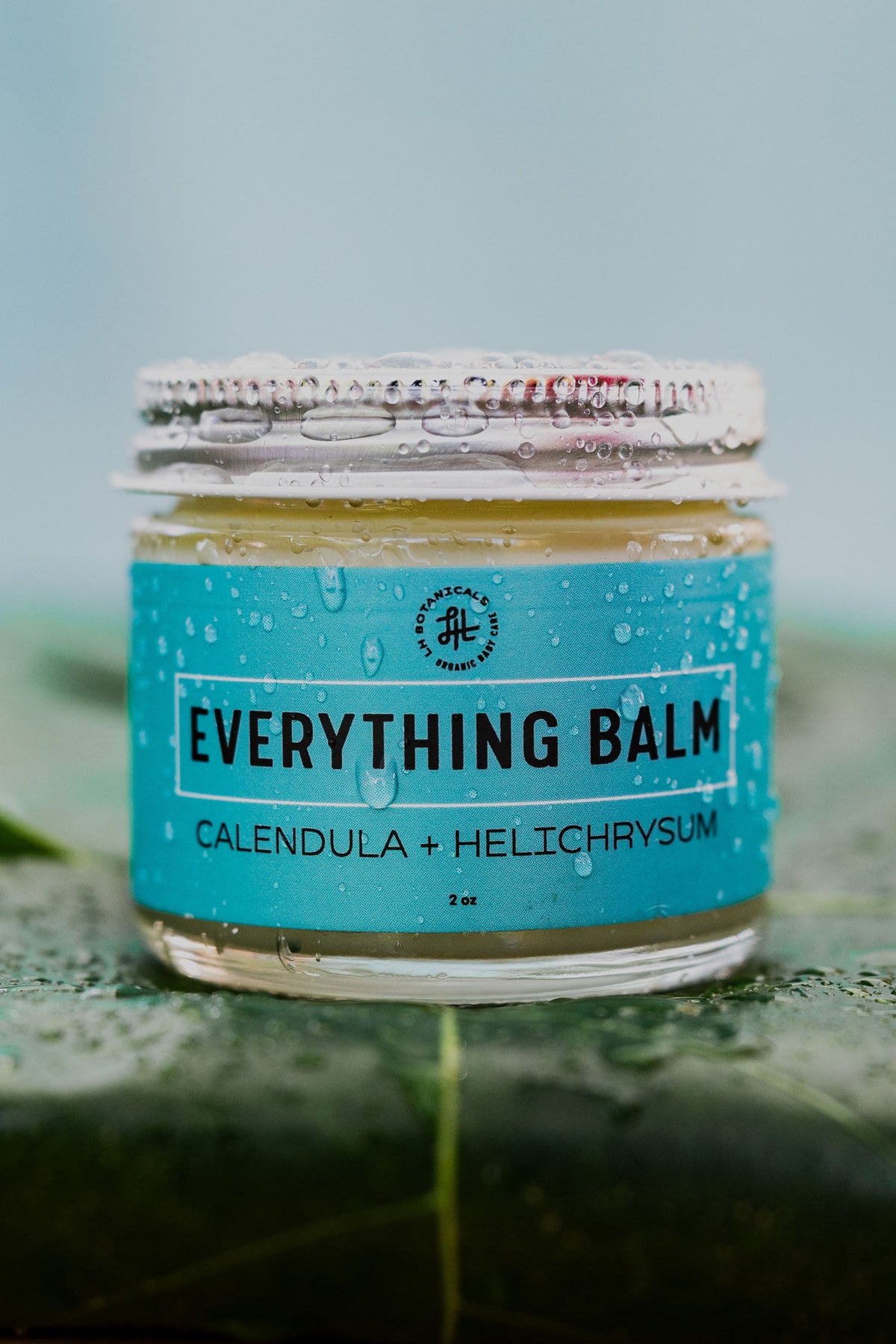 jar of everything balm on a leaf